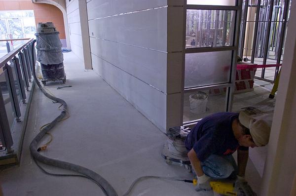 A Union construction worker lays down flooring Wednesday afternoon in a hallway outside the Atchafalaya Room.