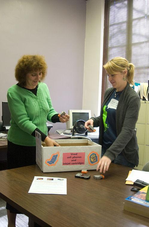 Psychology professor Katie Cheery, left, and Kelli Broome, elementary education junior and research assistant, show ink cartridges in a donation box Monday.