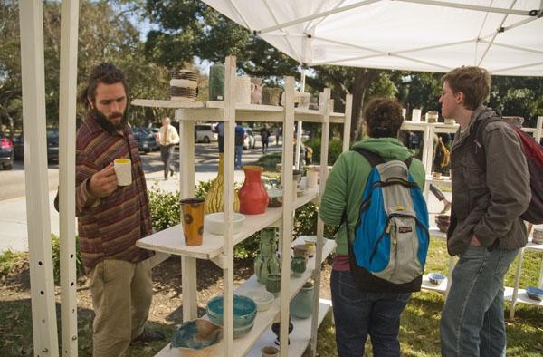 Aaron Smith, studio art senior, Jaclyn Smith, biological sciences senior, and Brian Allen, civil engineering senior, browse ceramics at C.A.S.A.&#8217;s pottery sale Wednesday.