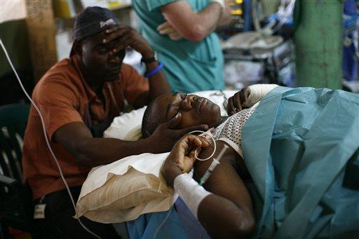 A translator sits with Emmanuel Etan as a team of British doctors amputate his right leg at their field hospital in Port-au-Prince, Tuesday, Feb. 9, 2010. Etan was injured in the 7.0-magnitude earthquake that hit Haiti on Jan. 12, killing and injuring thousands.