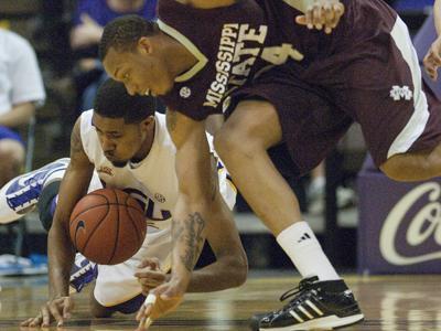 LSU freshman forward Dennis Harris, left, dives for a loose ball against Mississippi State junior forward Kodi Augustus during the Tigers&#8217; 60-59 loss on Saturday against the Bulldogs in the PMAC.