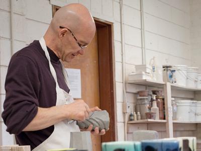 Andrew Martin, studio potter and author, demonstrates carving and molding techniques Tuesday during his ceramics workshop in the Engineering Shops.