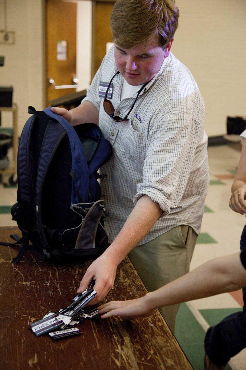 Student Government presidential candidate J Hudson lays "StudentsFIRST" buttons on a table Monday during a campaign ticket meeting in Coates Hall.