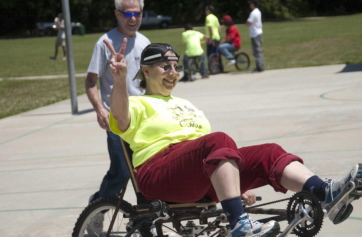 Baton Rouge Advocates for Safe Streets volunteer Pat Reily takes a ride on Dan Duhon&#8217;s homemade bike during Velo Louisiane on April 11.