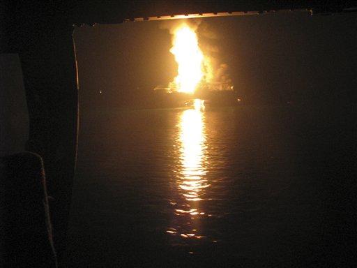 In this Wednesday April 21, 2010 photo released by the U.S. Coast Guard, a fire aboard the mobile offshore drilling unit Deepwater Horizon burns 52-miles southeast of Venice, La. Helicopters, ships and an airplane searched waters off Louisiana's coast Wednesday for missing workers after an explosion and fire that left an offshore drilling platform tilting in the Gulf of Mexico.