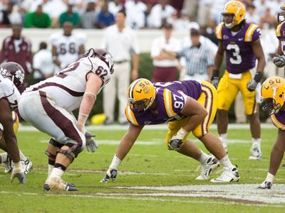 Former LSU defensive tackle Al Woods crouches before the snap against Miss. St. last season. Woods is projected as a fourth-round pick in part because of his size.