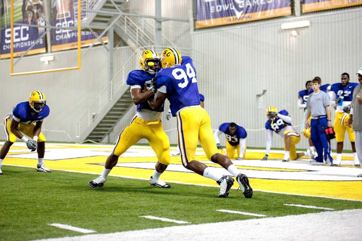 Junior defensive end Kendrick Adams (94) goes up against another defensive player in a drill March 9 at the indoor field of the Charles McClendon Practice Facility.