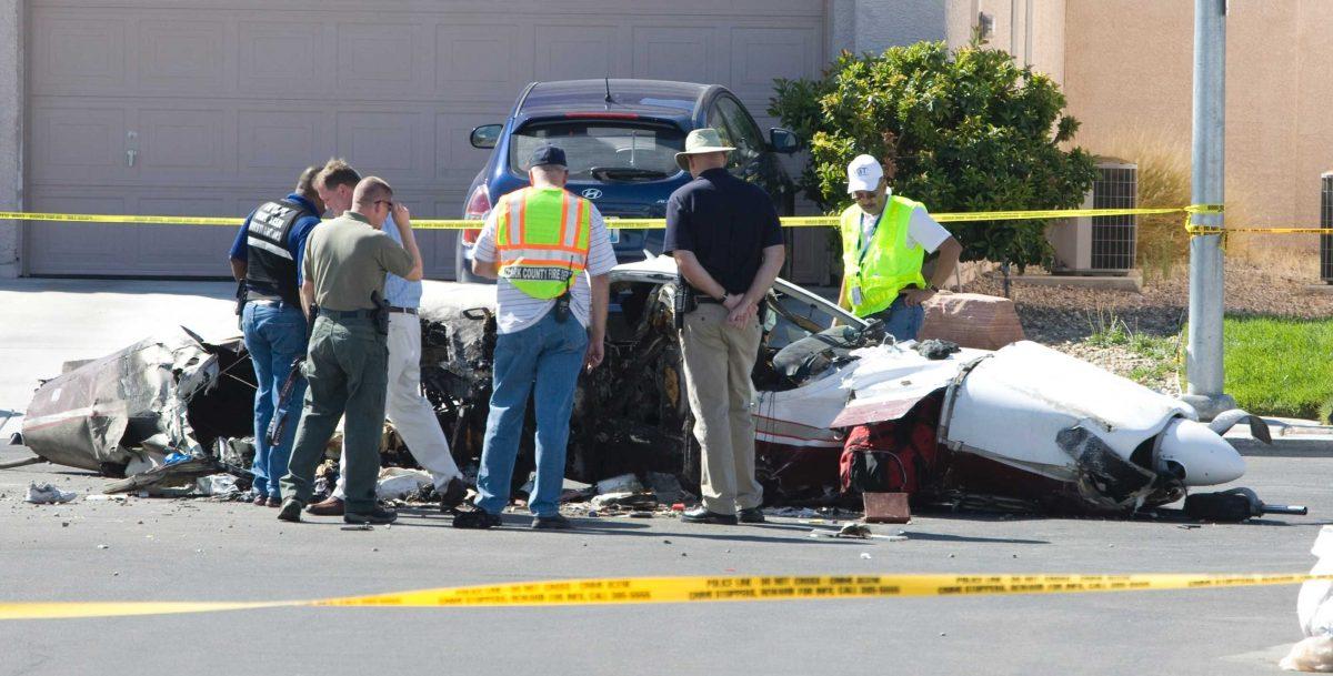 Fire and police officials look over the wreckage of a small plane after it crashed in a Nevada neighborhood Monday. Four Louisianians were involved in the crash.