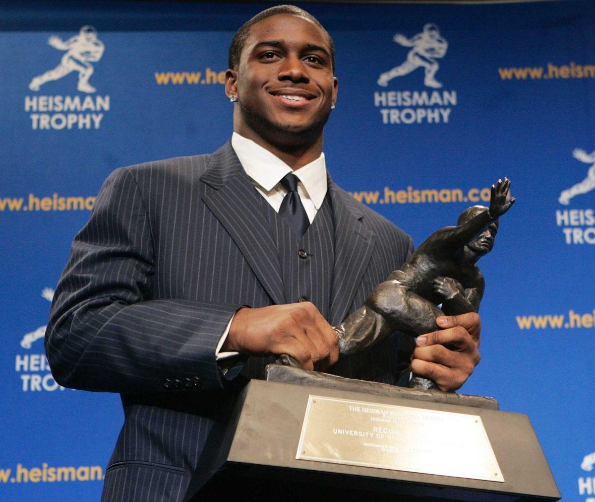 While still a player and student at USC, Reggie Bush poses with his Heisman Trophy on Dec. 10, 2005. Bush forfeited it Tuesday due because of an NCAA offense.