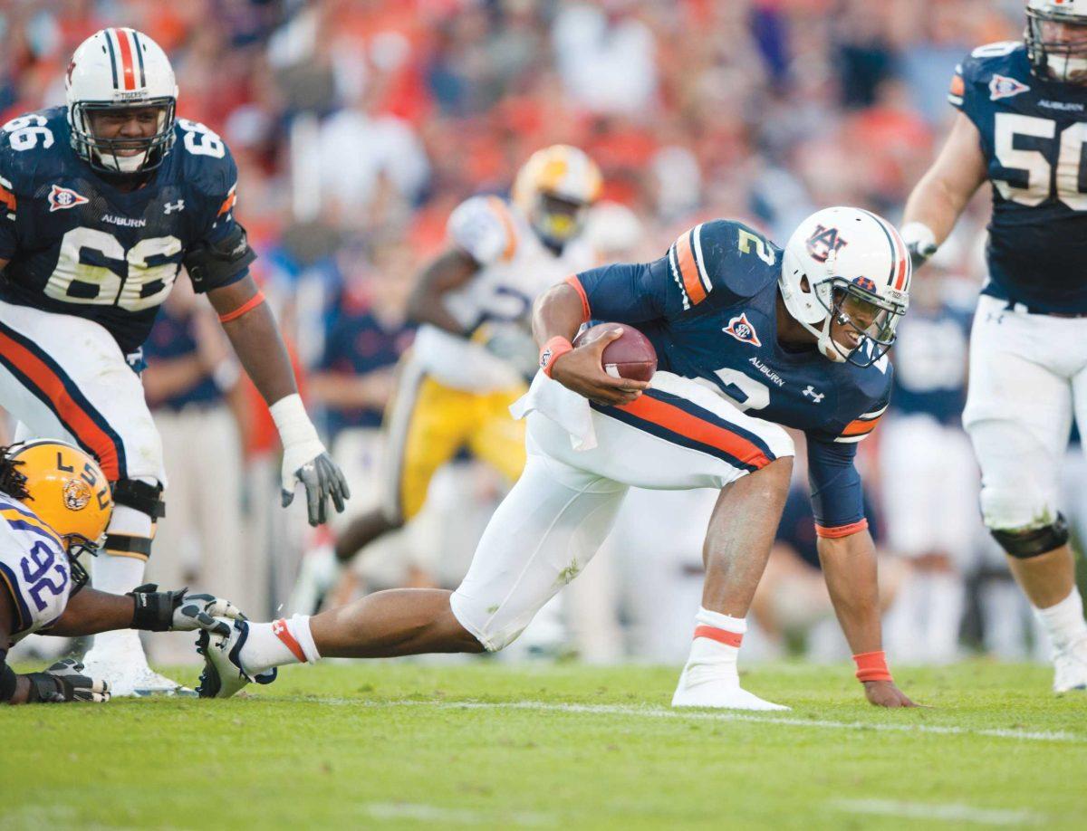 Auburn junior quarterback Cameron Newton (2) runs past LSU defensive tackle Drake Nevis (92) on Saturday during LSU&#8217;s 24-17 loss in Auburn, Ala.