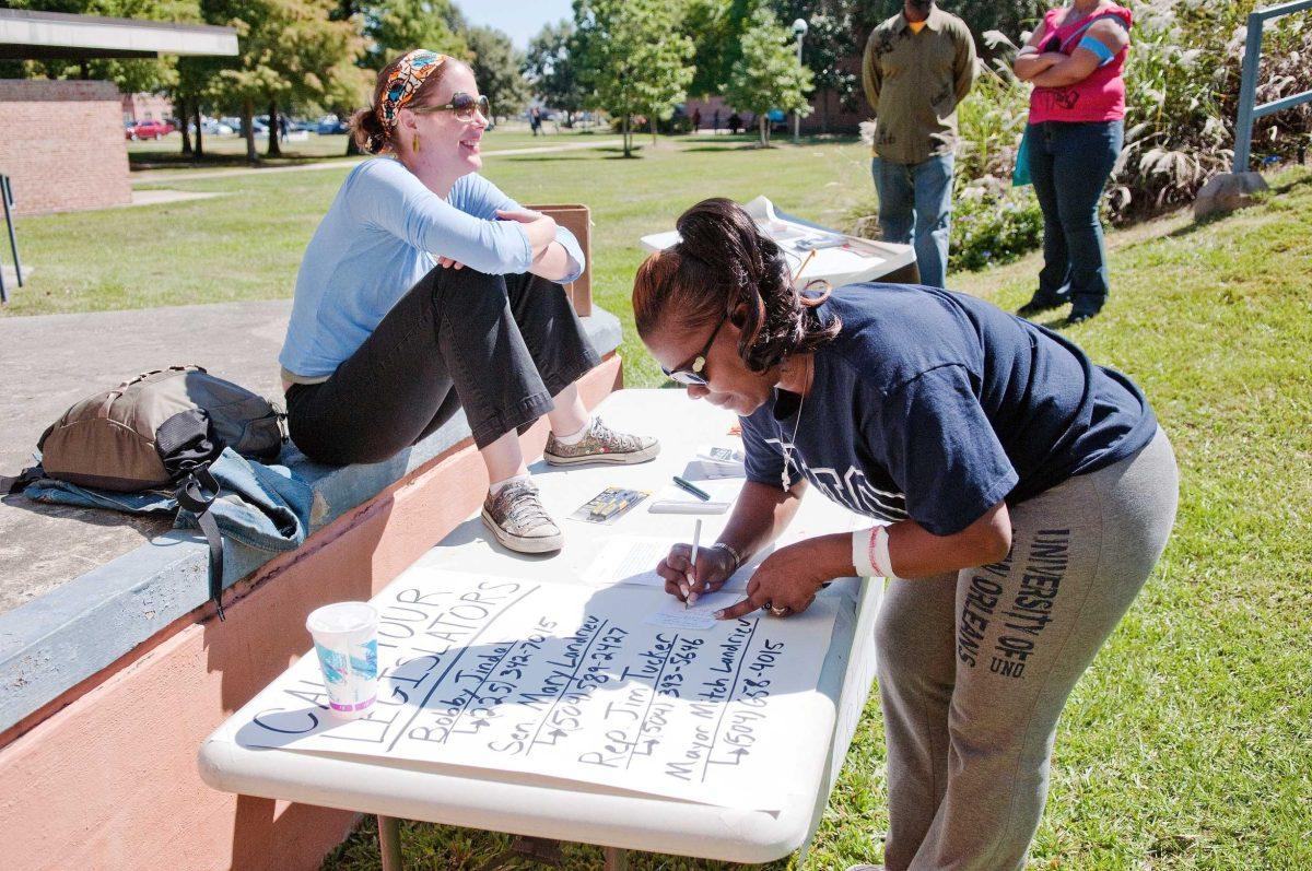 UNO interdisciplinary studies student Helen Larry, right, copies down legislators&#8217; numbers supplied at the booth manned by UNO urban studies graduate student Lauren Lastrapes, left, Wednesday at the Save UNO Block Party for Higher Education.