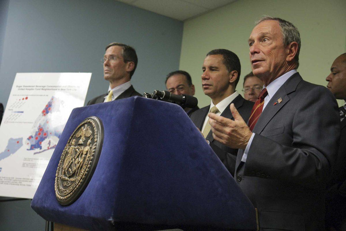 In this photo provided by the Mayor's office, New York City Mayor Michael Bloomberg, right, and New York Gov. David Paterson, center, attend a news conference to unveil an initiative excluding sugar-sweetened beverages from food stamp purchases Thursday, Oct. 7, 2010, in the Brooklyn borough of New York.