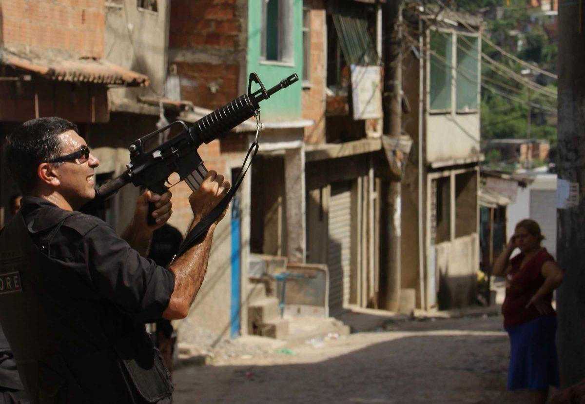 A police officer patrols in Complexo do Alemao slum in Rio de Janeiro on Monday, as efforts continued to locate drug gang members.