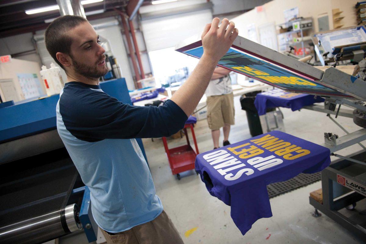 Tyler Lemoine, Giraphic Prints employee, views the finished product Monday of a T-shirt that reads &#8220;STAND UP GET CRUNK.&#8221; Giraphic Prints is developing into a prominent Baton Rouge business.