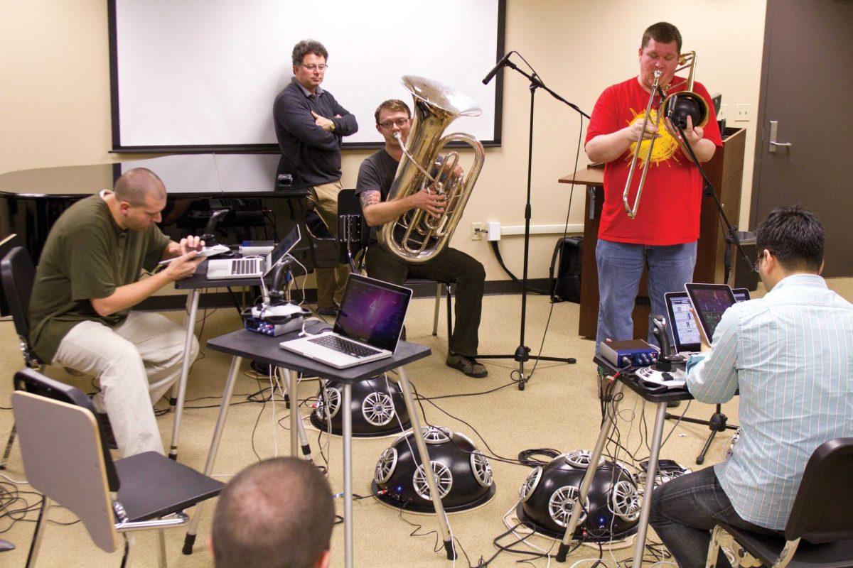 Members of the Laptop Orchestra of Louisiana use instruments, laptops, iPads and more Tuesday to create music during rehearsal.