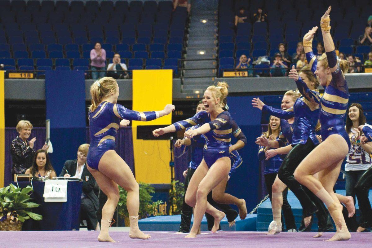 The LSU gymnastics team celebrates after senior Sam Engle scores a 9.90 in the floor event. The team went on to win in a 196.000-194.350 victory over New Hampshire in the 2011 home finale.