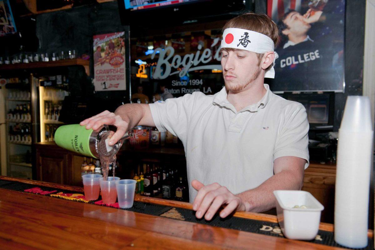 Steven Toubs, agricultural business junior, pours shots for patrons at Bogie&#8217;s Bar on Wednesday as part of the &#8220;Bogie&#8217;s Japan Relief Palooza&#8221; charity fundraiser.