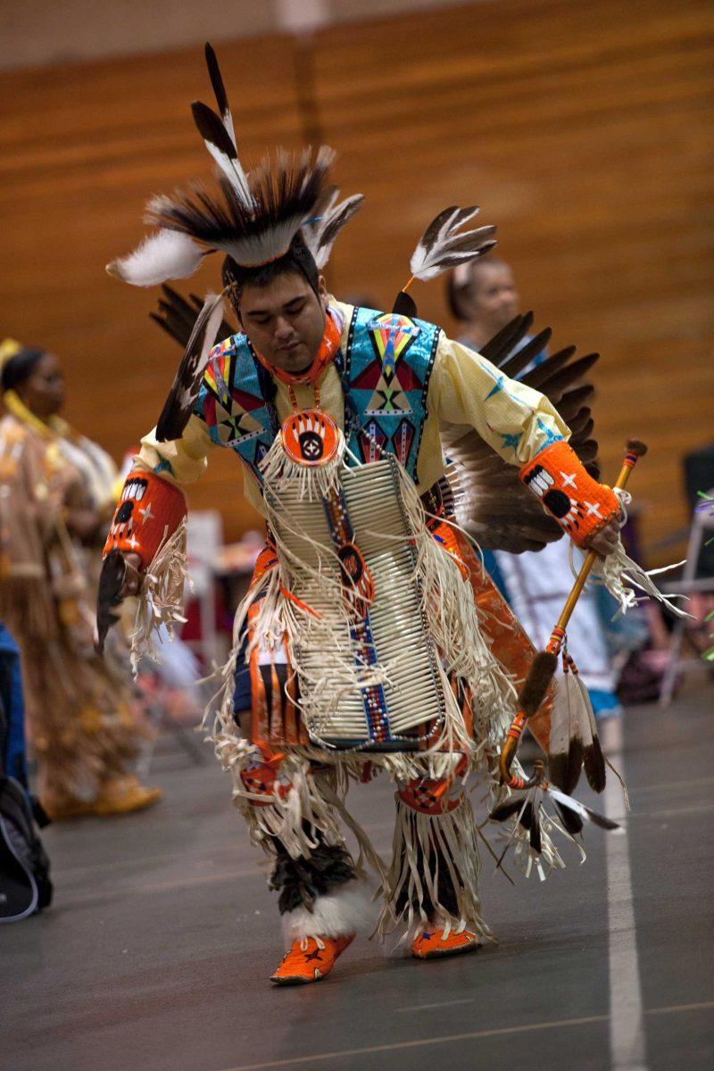 A Native American dressed in traditional garb dances Saturday at the Pow Wow hosted by the Native American Student Association at the Maddox Fieldhouse.