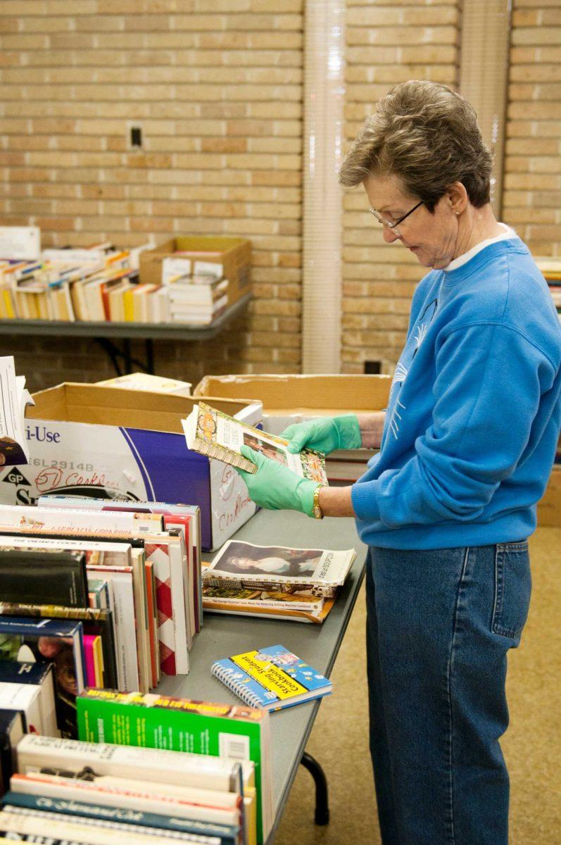 Pat Hoth helps organize books for the Book Bazaar. The annual sale opens today at the 4-H Mini Farm and Nelson Memorial Building, across from Parker Coliseum.