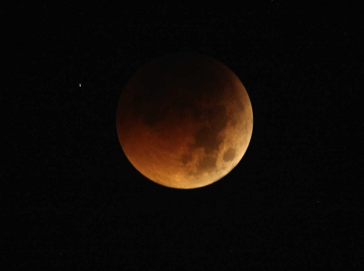 The Earth completely casts its shadow over the moon in a total lunar eclipse as seen in Manila, Philippines, before dawn Thursday.