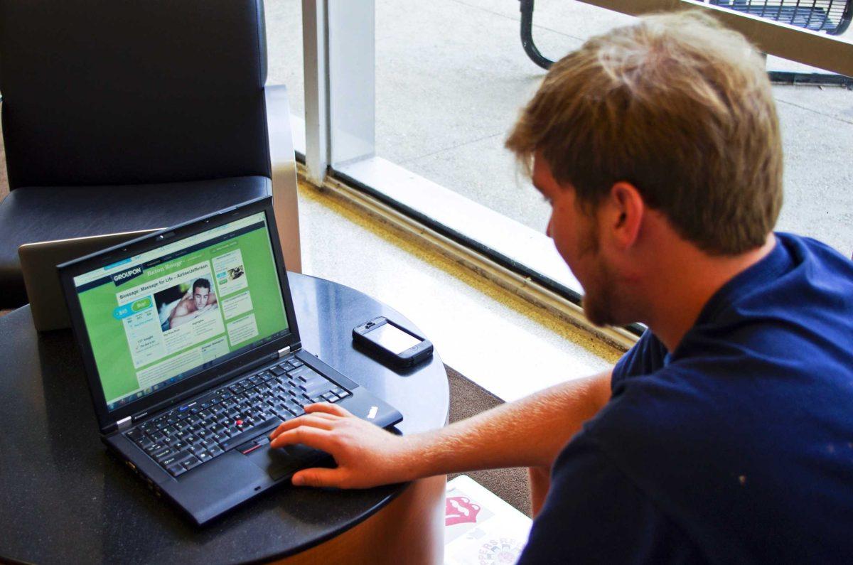 Travis Campbell, political science junior, uses Groupon&#8217;s website Monday to look for deals. Groupon has become popular among college students looking to save money.