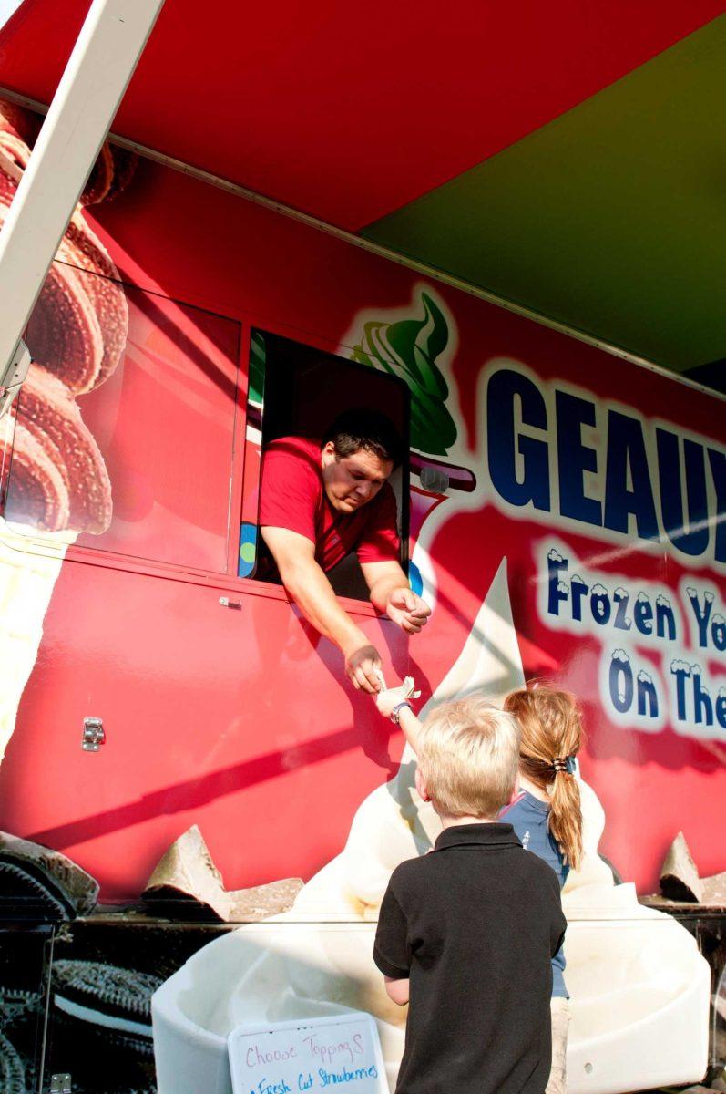 The Geaux-Yo food truck serves frozen yogurt to kids Wednesday on Perkins Road.