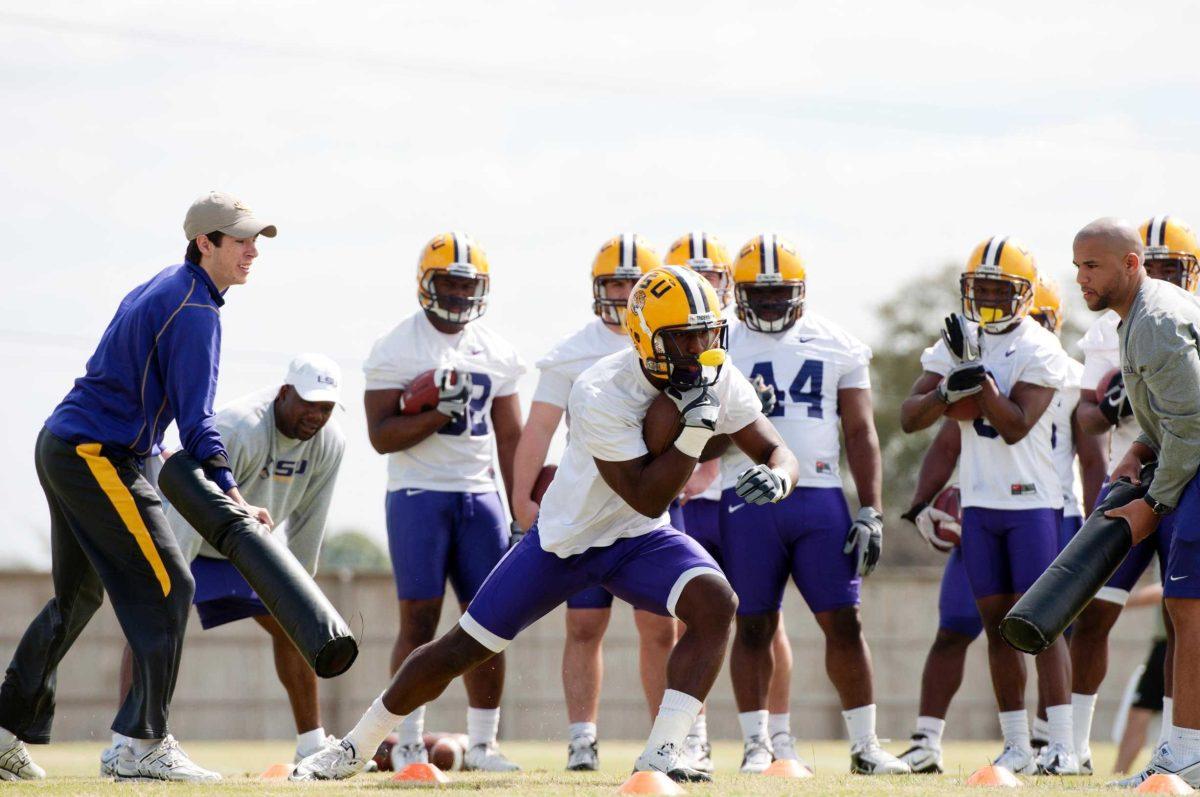 Sophomore running back Alfred Blue (4) sprints in a drill April 5 during spring pratice. Sophomore running back Spencer Ware (11) stands behind Blue.