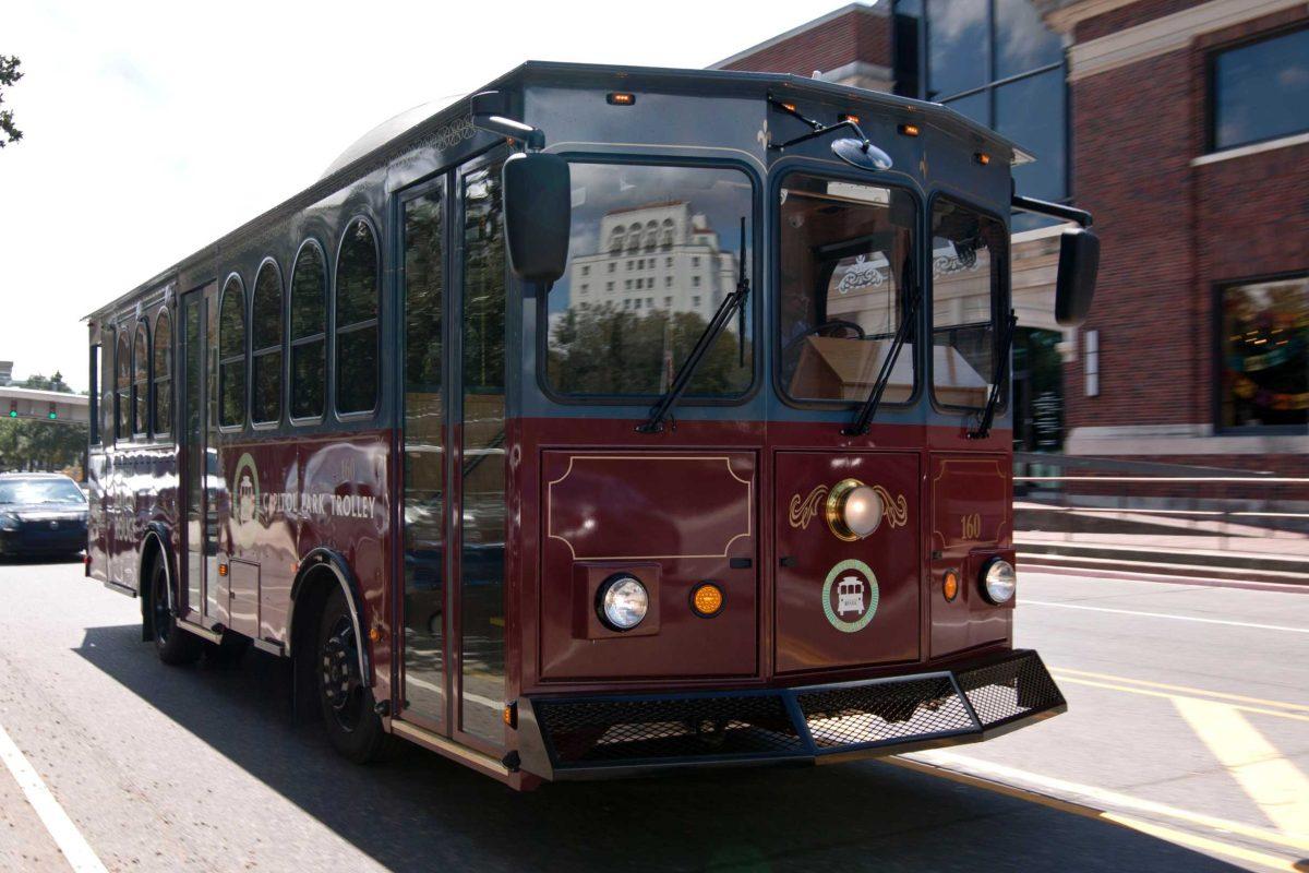 One of three new trolleys carries passengers through the downtown area Tuesday. These trolleys will be the driving force behind Trolley Rouge.