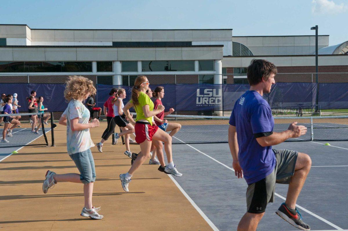 At the Monday evening session of TigerFIT, instructor Mark Romanoski leads his group across the UREC tennis courts. Students are coached as they perform various physical challenges.