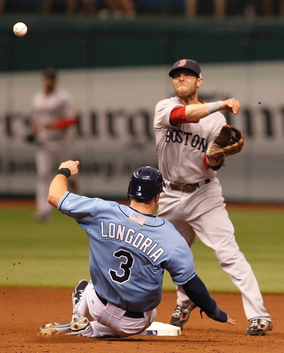 Boston Red Sox second baseman Dustin Pedroia throws to first Sept. 11 after forcing out Tampa Bay Rays&#8217; Evan Longoria during a baseball game in St. Petersburg, Fla.