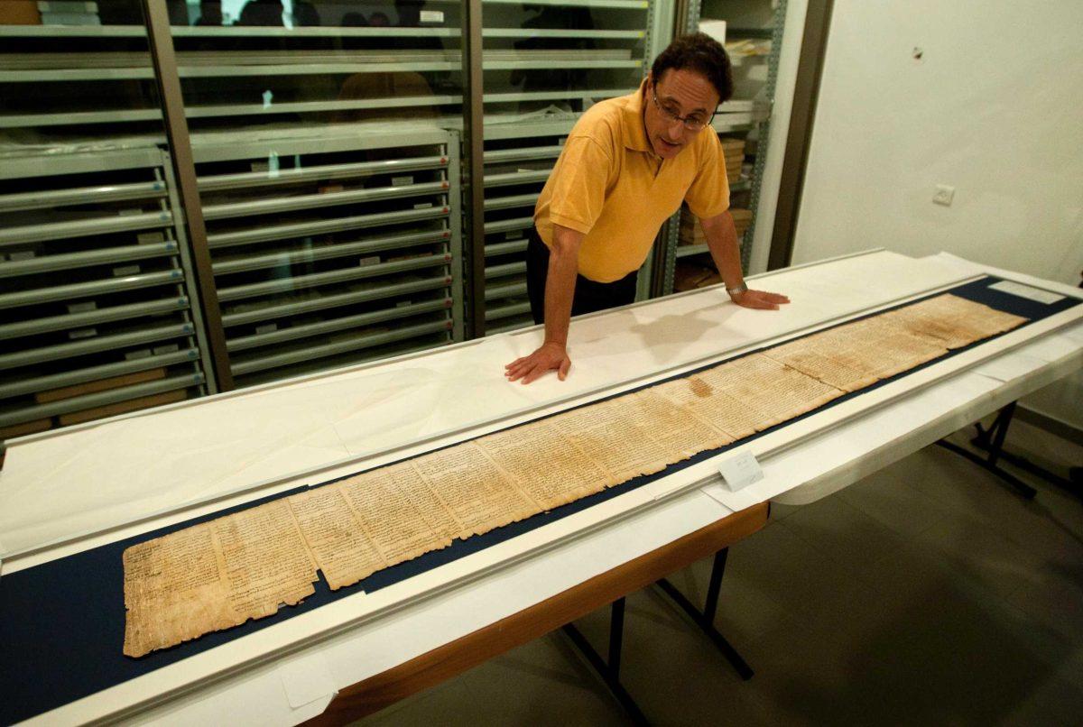 Dr. Adolfo Roitman presents a part of the Isaiah Scroll, one of the Dead Sea Scrolls, inside the vault of the Shrine of the Book building at the Israel Museum in Jerusalem on Monday.