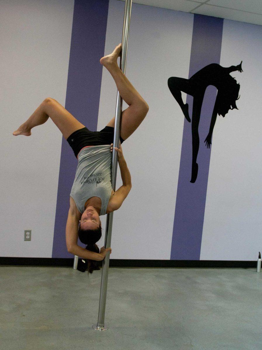 One of Perfect Poleforma's instructors, Ashley Torrence, shows students pole dancing moves.