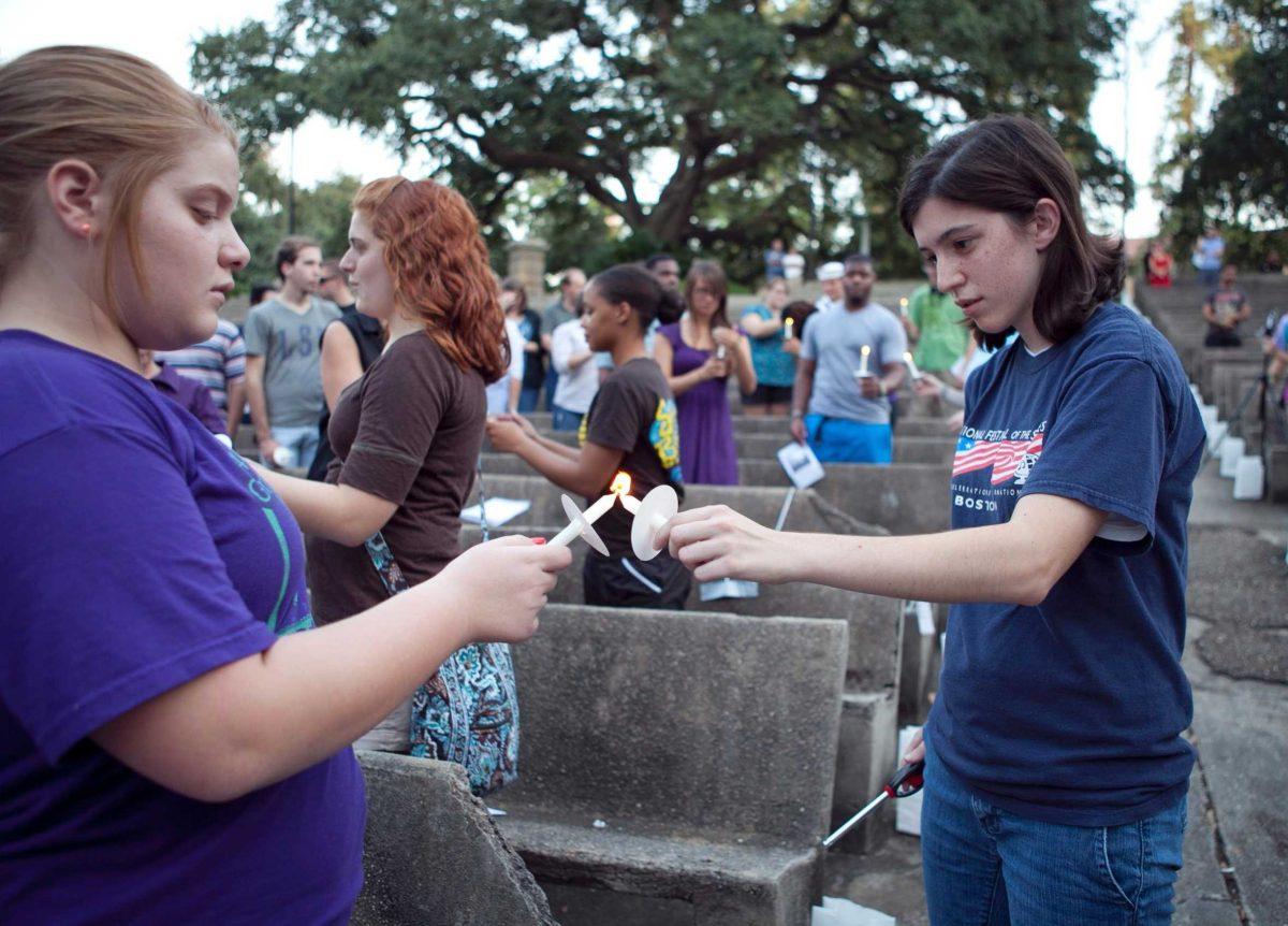 Students light candles before a vigil held for the victims of the 9/11 attacks in the Greek Ampitheater on Sunday.