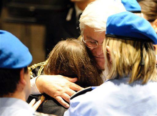 Amanda Knox, back to camera, hugs her lawyer Luciano Ghirga following the verdict that overturns her conviction and acquits her of murdering her British roomate Meredith Kercher, at the Perugia court, Italy, Monday Oct. 3, 2011. An Italian appeals court has thrown out Amanda Knox's murder conviction and ordered the young American freed after nearly four years in prison for the death of her British roommate. Knox collapsed in tears after the verdict was read out Monday.