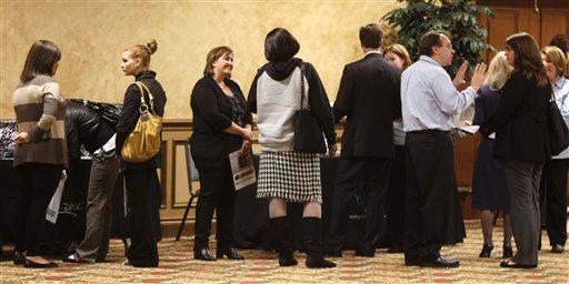 Job seekers talk with prospective employers at a job fair Wednesday, Oct. 26, 2011, in Brookpark, Ohio. The number of people seeking unemployment benefits dipped slightly last week, though not by enough to suggest that hiring is picking up.