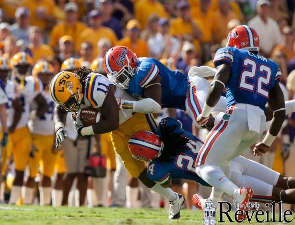 Sophomore running back Spencer Ware (11) runs through Florida's defenders during the game on Saturday.