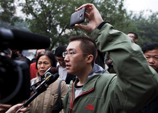 Qi Jianxiang, son of an activist Wang Lihong, speaks to the journalists while using his mobile phone to record video footage of his surrounding after attending his mother's court appeal case in Beijing, China, Thursday, Oct. 20, 2011. The Beijing No. 2 Intermediate People's Court on Thursday upheld the conviction of Wang for creating a disturbance when she helped lead a protest on behalf of three bloggers accused of slander.