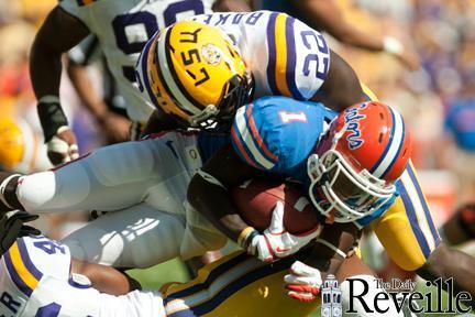 Florida senior running back Chris Rainey (1), who also lined up against LSU as quarterback Saturday, gets tackled by senior linebacker Ryan Baker (22).