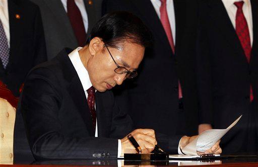 South Korean President Lee Myung-bak signs bills needed to implement the country's free trade deal with the United States at the presidential house in Seoul, South Korea, Tuesday, Nov. 29, 2011. (AP Photo/Jin Sung-chul, Yonhap)