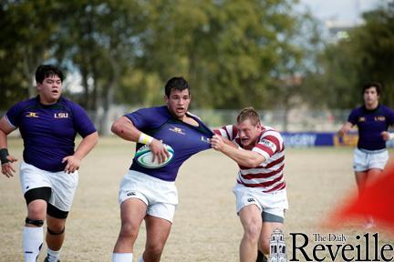 LSU rugby player Cameron Falcon (center) tries to push past a Florida State player during the LSU-FSU rugby match Saturday at the SAC Fields. The Tigers lost, 22-20.