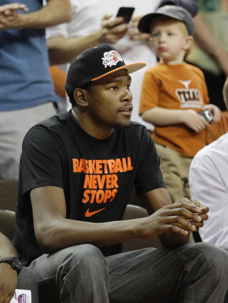 Oklahoma Thunder's Kevin Durant, a former Texas player, watches an NCAA college basketball game between Rhode Island and Texas, Tuesday, Nov. 15, 2011, in Austin, Texas. (AP Photo/Eric Gay)