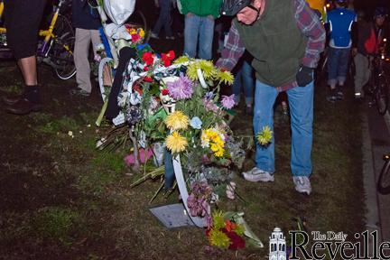 Friends and family of Nathan Crowson stop at the ghost bike memorial to deliver flowers Saturday during a Critical Mass bike ride.