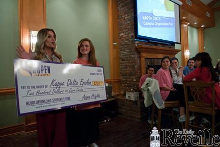 Erica Moffatt [left], Aspen Heights sales and marketing manager, presents a $200 check to the Kappa Delta sorority Monday at their weekly meeting. Kappa Delta came in second place in the Facebook competition.