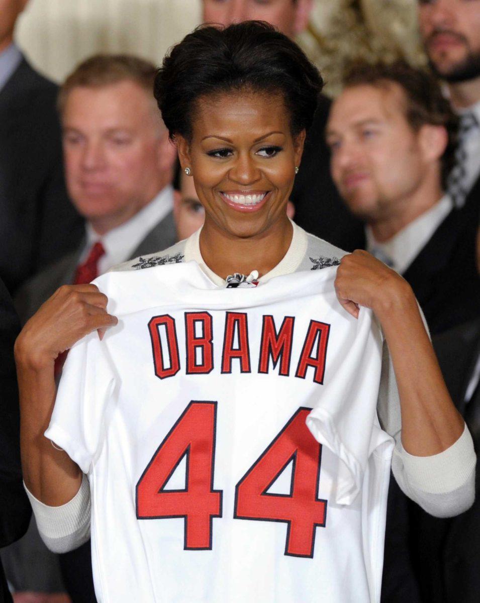 First lady Michelle Obama displays a St. Louis Cardinals team baseball jersey during a ceremony in the East Room of the White House in Washington, Tuesday, Jan. 17, 2012, where she and President Barack Obama honored the 2011 World Series baseball Champion St. Louis Cardinals. On Tuesday, Mrs. Obama celebrated her 48th birthday. (AP Photo/Susan Walsh)