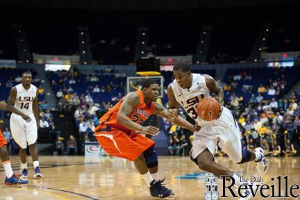 In this January 17, 2012 photo, LSU freshman guard John Isaac (32) fiercely moves past Auburn's Kenny Gabriel (22) as he goes to score for LSU during the Tigers' 65-58 victory against Auburn.