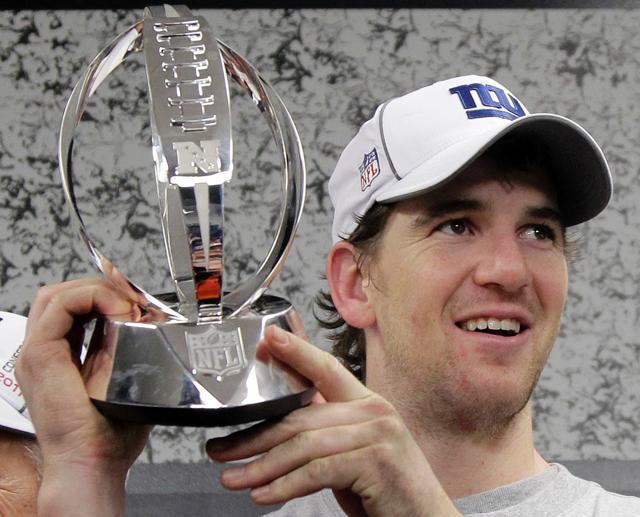 New York Giants Eli Manning lifts the George Halas Trophy in the locker room after the Giants won in overtime at the NFC Championship NFL football game Sunday, Jan. 22, 2012, in San Francisco. The Giants won 20-17 to advance to Super Bowl XLVI.