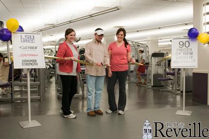 Speaker Pro Temp Abbey Vaughn (left) and Student Government Vice President Kathleen Borledon (right) join SG President Cody Wells (center) on Tuesday at the All Access event as he cuts the ribbon for the new weight equipment in the UREC.