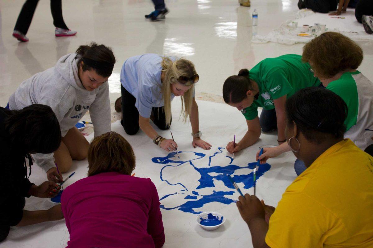 Students, teachers and volunteers at Belaire High School paint murals Monday promoting school spirit and enthusiasm during Martin Luther King Jr. Day of service. Additional MLK commemorative events will be held throughout the month.