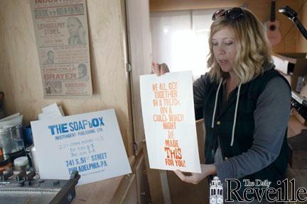 Kyle Durrie shows prints she made in the Type Truck during her cross-country tour, Moveable Type, Thursday while parked on campus.