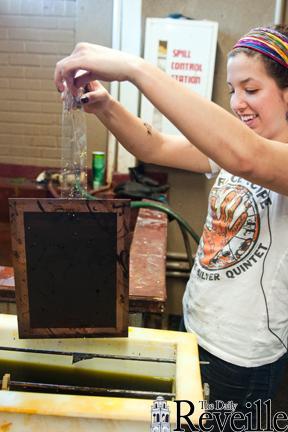 Katherine Santana, printmaking junior and member of the University Print Club, demonstrates the acid wash process Tuesday.